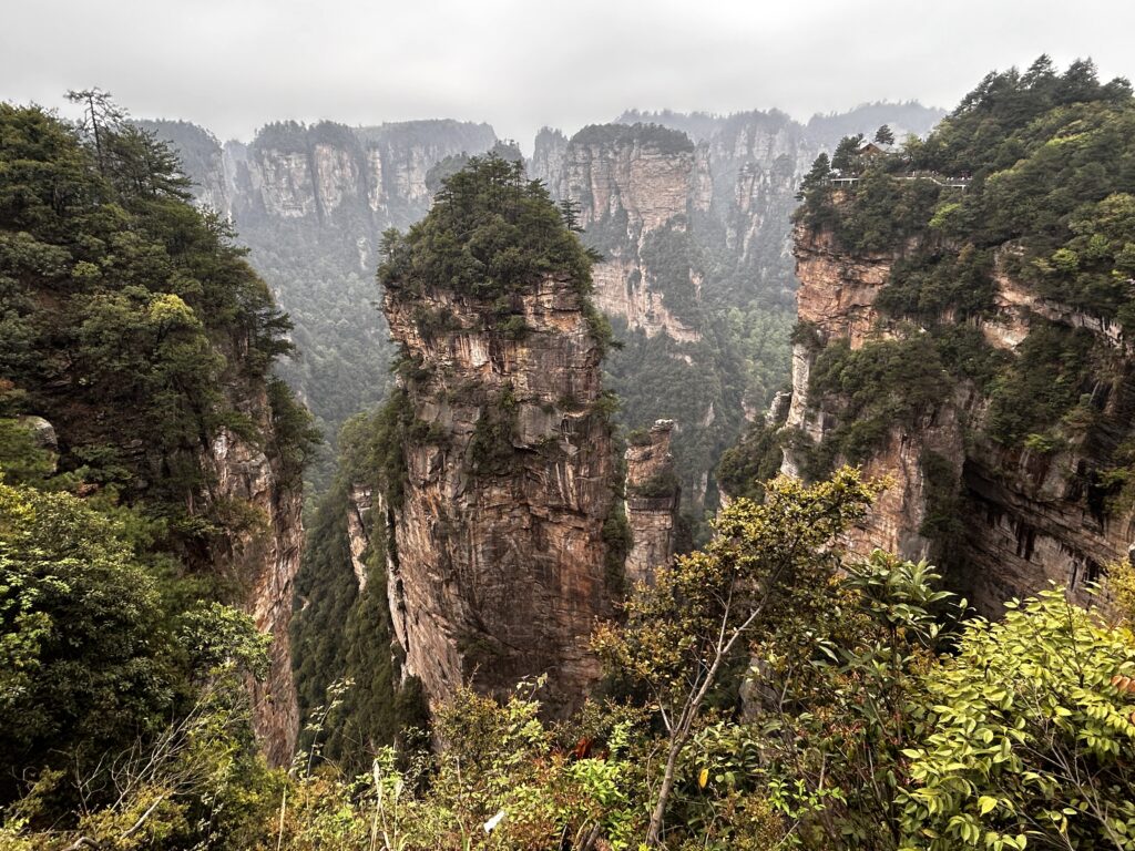 Layered sandstone pillars rising above forest in Wulingyuan, Zhangjiajie