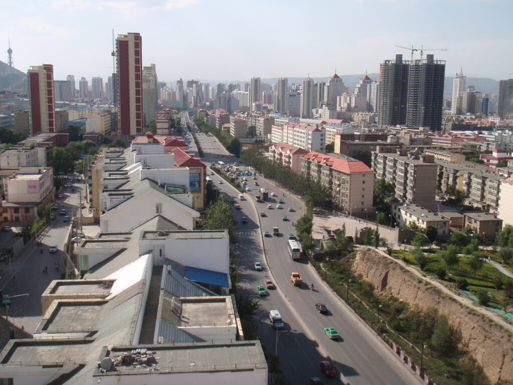 A broad view over Xining's city streets and high-rise buildings with highland slopes beyond