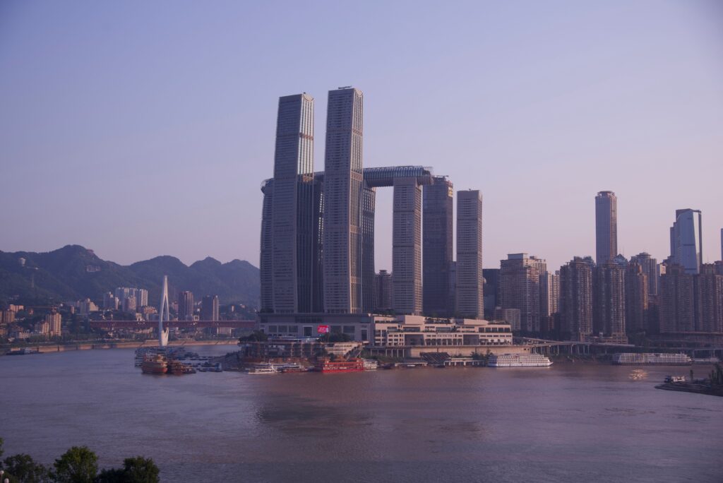 Chongqing skyline with Raffles City, the river and a bridge at dusk