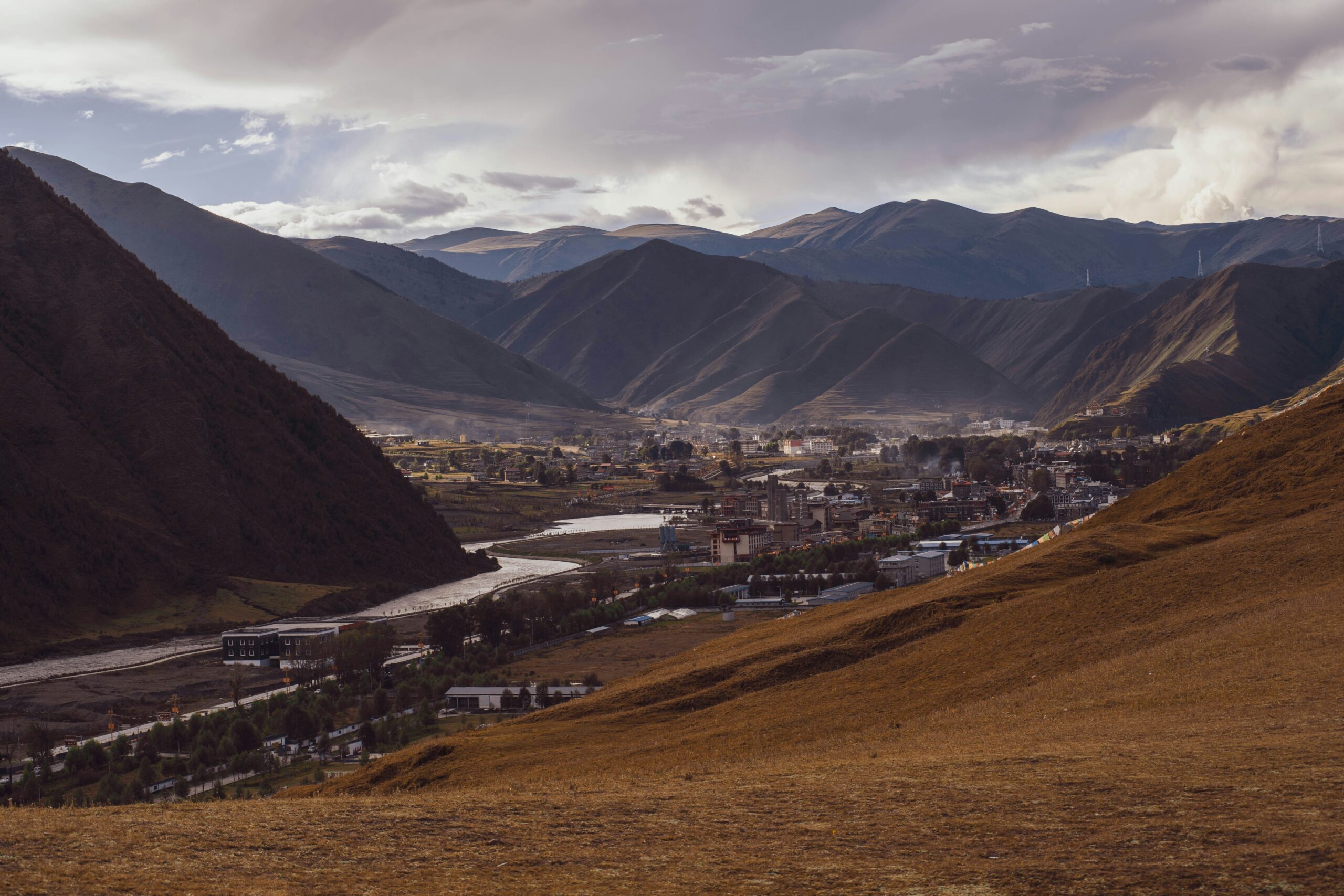 Qinghai valley town beside a winding river and layered mountain ridges