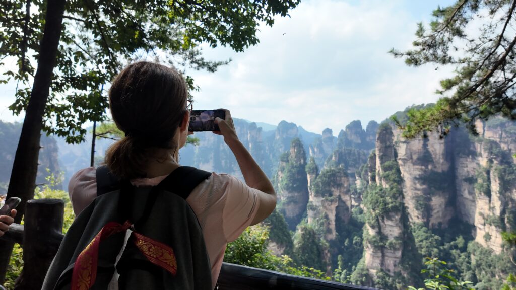 Traveler photographing sandstone pillars in Zhangjiajie National Forest Park
