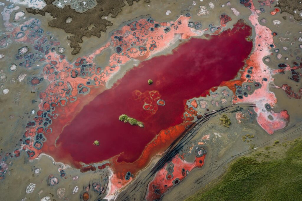 Aerial view of a red salt lake and mineral patterns in Badain Jaran Desert, China
