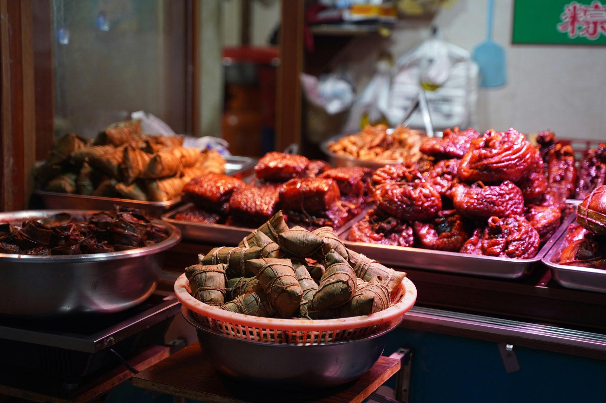 Traditional Chinese street-food stall with wrapped rice dumplings and braised dishes