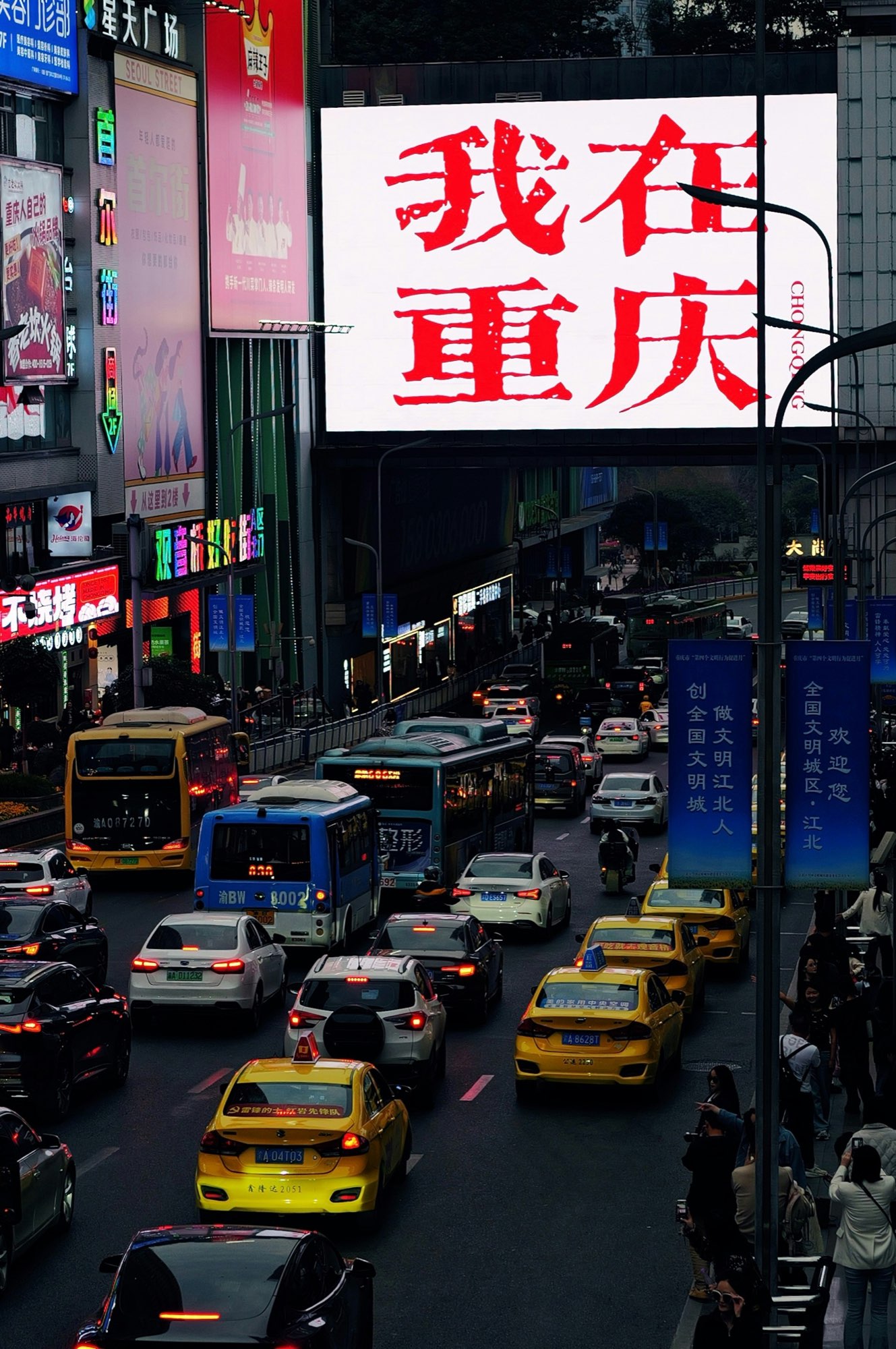 Evening traffic and illuminated signs in downtown Chongqing