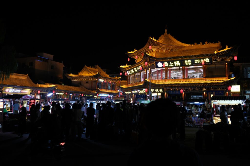 Illuminated traditional Chinese buildings and lanterns on a busy night street