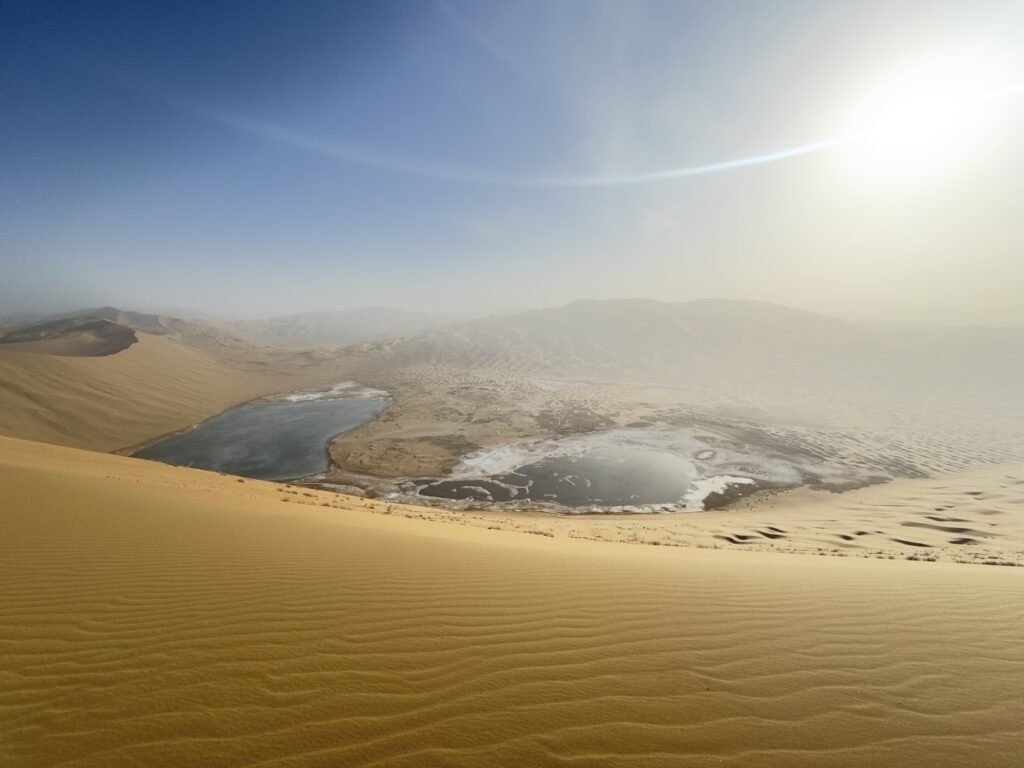 Desert lakes surrounded by golden sand dunes viewed from above
