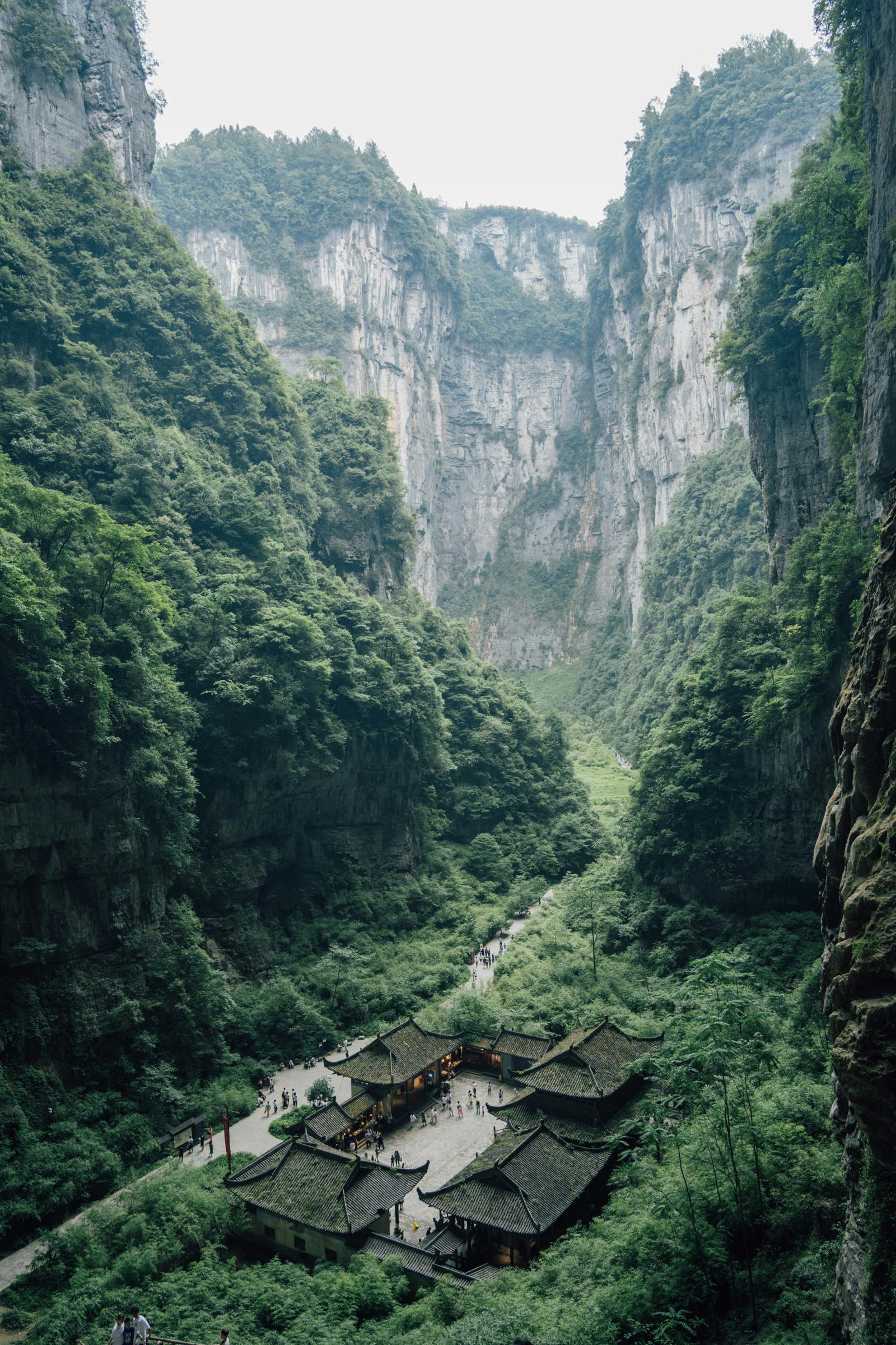 Forested limestone gorge and traditional buildings in Wulong, Chongqing