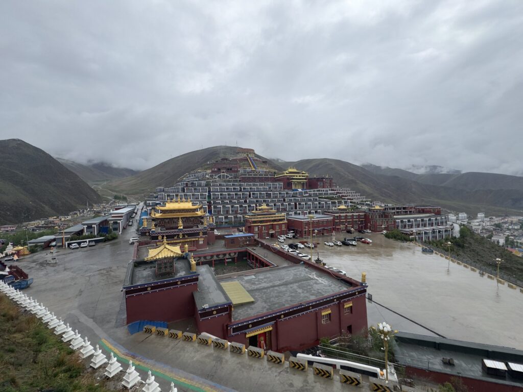 Tibetan monastery complex surrounded by misty mountains in Yushu