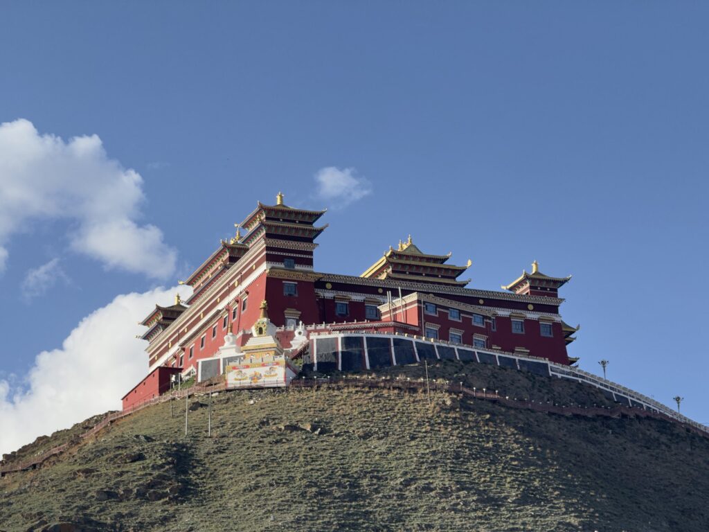 Yushu monastery with red and gold Tibetan buildings on a mountain slope