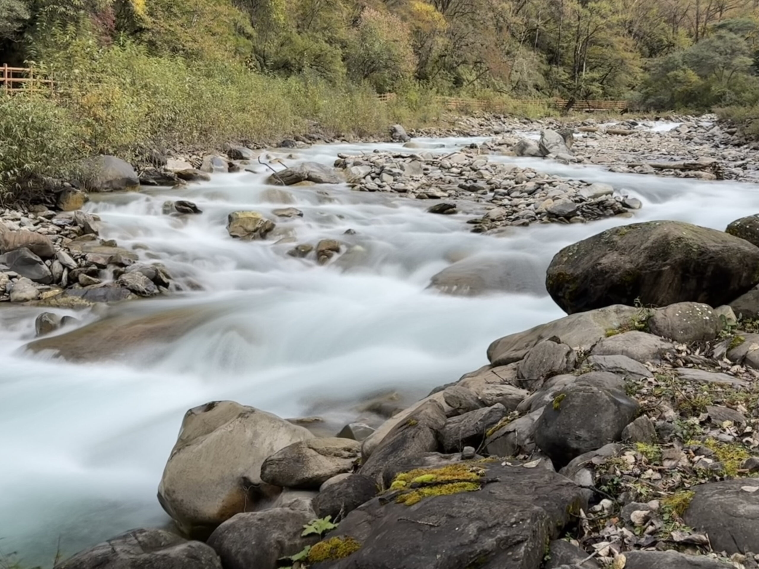 Smooth river flowing through a rocky forest valley