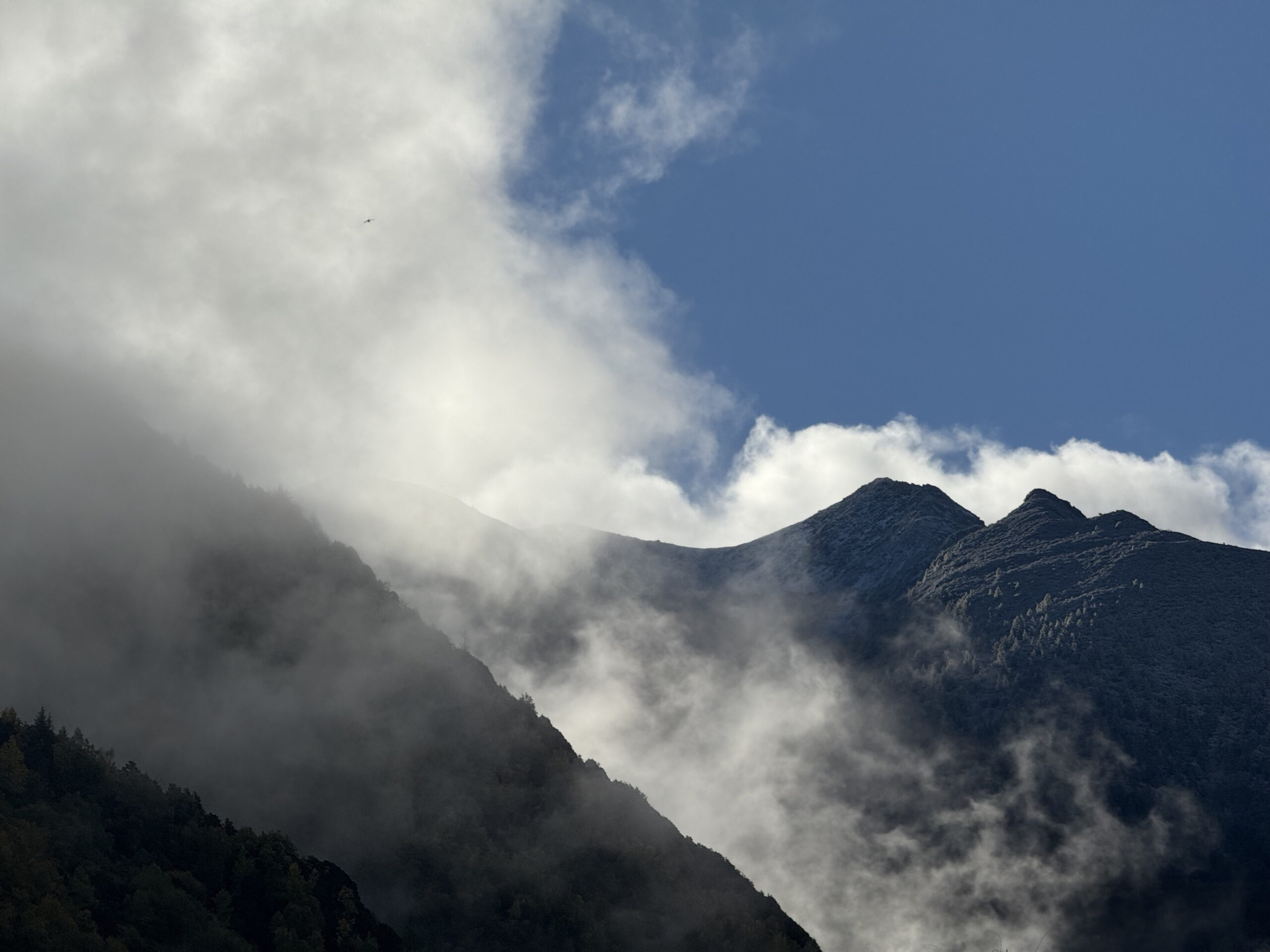 Snow-dusted mountain peaks above the clouds